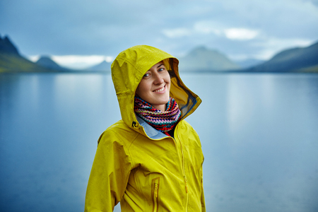woman on the Lake coast with mountain reflection at the rainy day, Icelandの写真素材