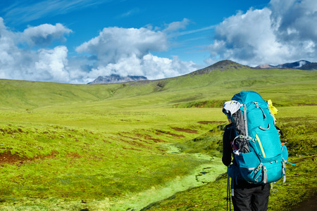 woman hiker on the trail in the Islandic mountains. Trek in National Park Landmannalaugar, Iceland. valley is covered with bright green mossの写真素材