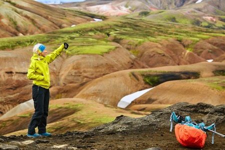 woman hiker photographer taking selfie on the rhyolite mountains background in Icelandの写真素材