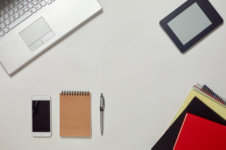 Creative Office Bright Table with laptop Keyboard, eBook, notebooks and smartphone. Top View with Copy Spaceの写真素材