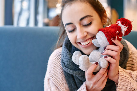 Couple in love on a date. A woman receives a gift from a man. Presented with a teddy bear in a red cap. Love story and Valentines Day conceptの写真素材