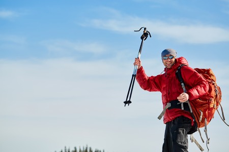 hiker in red down jacket with backpack near the tent in the Carpathians mountains at winterの写真素材