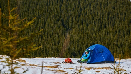 hiker resting near the tent in the Carpathians mountains at winterの写真素材