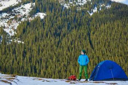 hiker resting near the tent in the Carpathians mountains at winterの写真素材