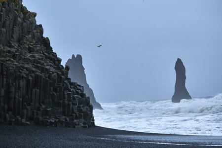 Reynishverfisvegur, Reynisfjara black sand beach with rocks, ocean and dark rain and storm clouds near the village of Vik in Iceland.の写真素材