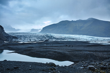 Glacial lagoon in Iceland in the fall. Cloudy foggy weather, mountains on the horizon. The glacial lake reflects the sky, glacier and mountainsの写真素材