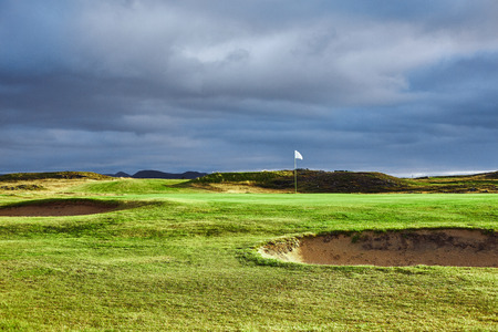 landscape view of golf course in Iceland. Green grass and blue cloudy skyの写真素材