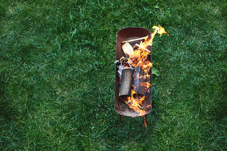 flame grilled and wood burning in fire. family BBQ party in outdoor or home garden. fireplace on the grass.の写真素材