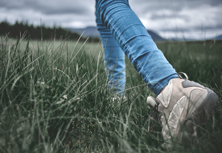feet of woman hiker hiking in beautiful mountainson the green pines backgroundの写真素材