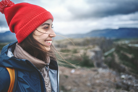 close up portret of Girl in warm clothing observing surroundings on background of mountains of Iceland.の写真素材