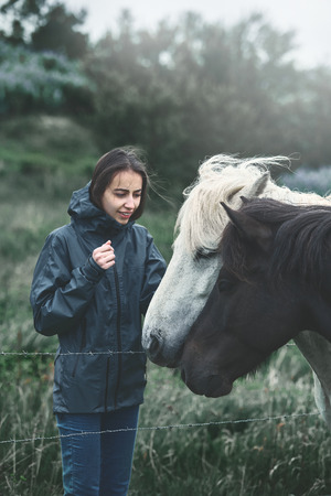 Travel to Iceland. a woman stroking a horse in the fieldの写真素材