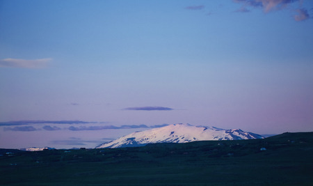 Travel to Iceland. Beautiful Icelandic evening landscape with green fields, mountains, sky and moon.の写真素材