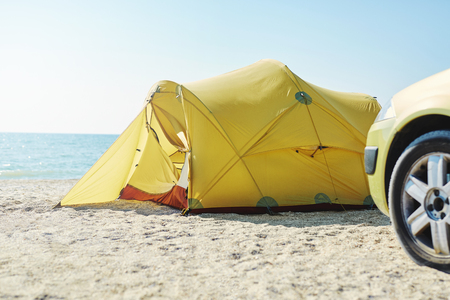 yellow tent and car on the beach at bright sunny day. Travel photography conceptの写真素材