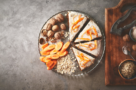 product set and sliced vegan carrot pie on the dish on gray concrete backdrop. view from above with copyspaceの写真素材