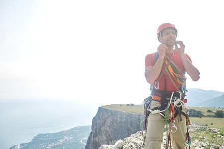 man rock climber climbed on the cliff. happy climber on the top of the mountain.の写真素材
