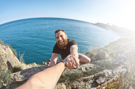 man shows a heavy climbing on a rock with funny face