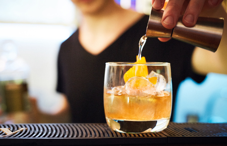 bartender prepares a colorful cocktail on the bar table in restaurantの写真素材