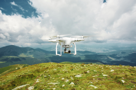 drone quadcopter with digital camera in the mountains. The drone with camera takes pictures of the misty mountains. quadcopter drone flying with digital camera on the sky.