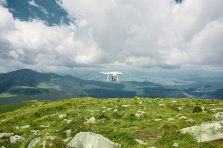 drone quadcopter with digital camera in the mountains. The drone with camera takes pictures of the...