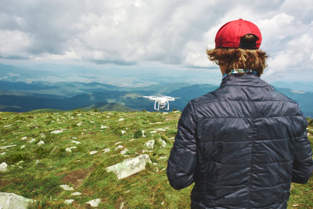 man playing with the drone. drone quadcopter with digital camera in the mountains. The drone with...