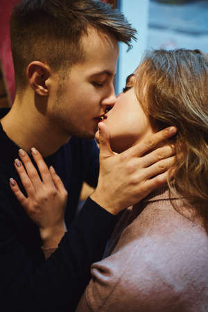 Happy romantic couple ambracing and kissing in cafe. boyfriend and girlfriend spending time together in the city, having a date. urban romantic portrait. Romantic, love and Valentine's Day concept.の写真素材