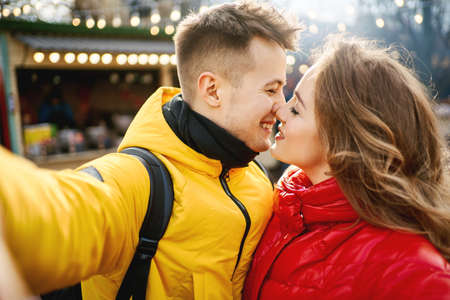 young romantic couple in love making selfie, smiling and kissing. Spending time together in the city, having a date. urban romantic portrait. Romantic, love and Valentine's Day concept.の写真素材