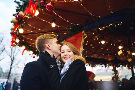 elegant fashionable romantic couple in love hugging and kissing on bright red festive decorations background. Spending time together in the city, having a date. urban romantic portrait. Romantic, love and Valentine's Day concept.の写真素材