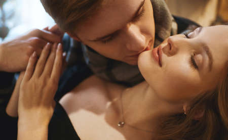 closeup portrait of beautiful blonde woman with closed eyes, handsome man tenderly kissing his girlfriend in neck. sensuality, love and Valentine's Day concept.の写真素材