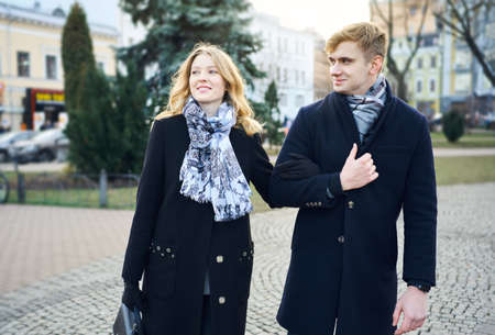 elegant stylish romantic couple walking city street. boyfriend and girlfriend enjoying a date, wearing in black coats. urban romantic portrait. Romantic, love and Valentine's Day concept.の写真素材