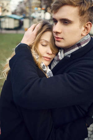 young man tenderly embracing his girlfriend, feeling comfortable, happy moments together. urban romantic portrait. Romantic, love and Valentine's Day concept.の写真素材