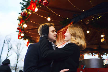 elegant romantic couple in love embracing and touching each other on festive decorations background. Spending time together in the city, having a date. urban romantic portrait. Romantic, love and Valentine's Day concept.の写真素材
