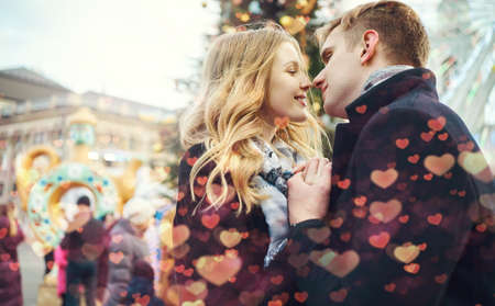 happy romantic couple in love smiling, kissing, hugging, close to each other outdoors. Spending time together in the city, having a date. urban romantic portrait. Romantic, love and Valentine's Day concept. tinted image with bokehの写真素材