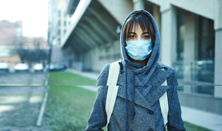 woman wearing face protection in prevention for coronavirus in city, modern building on background....