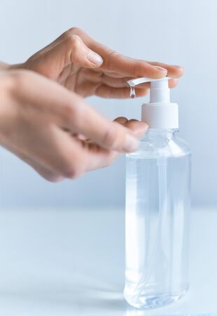 Close-up hand using alcohol antiseptic gel prevent for germs, bacteria and virus. Clear sanitizer in pump bottle for hand hygiene corona virus protectionの写真素材