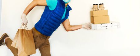 Courier in uniform gloves carrying many cardboard boxes, running and hurrying to deliver takeout food. Takeout food, online order, delivery serviceの写真素材
