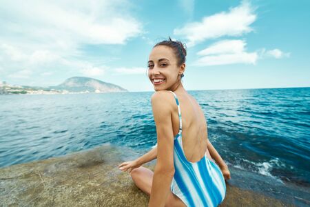 joyful woman smiling to camera and enjoying sea ocean view against blue sky. concept summer sea vacation, travel and freedomの写真素材