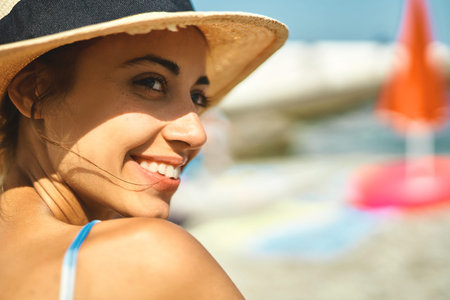 Close-up portrait summer woman in straw hat smiling and enjoying summer sea vacation in hot sunny...