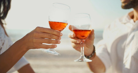 Close-up two glasses of champagne or wine in hands cheering, couple celebration and having romantic...