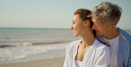 Close-up portrait cheerfulness couple at seashore, man touching the nose to woman neck. Love moments together during travel vacation. Authentic people portrait conceptの写真素材