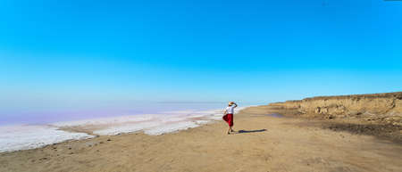 Panoramic image beautiful landscape, woman walking at beach near salt pink lakeの写真素材