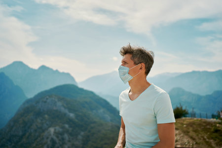 Tourist man wearing face mask enjoying amazing mountains view, traveling vacation to Turkey during...