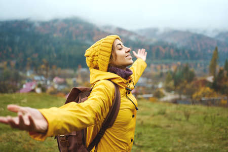 Carefree girl feeling good in mountains hiking, standing with closed eyes and open arms, enjoying outdoor activity and wanderlust lifeの写真素材