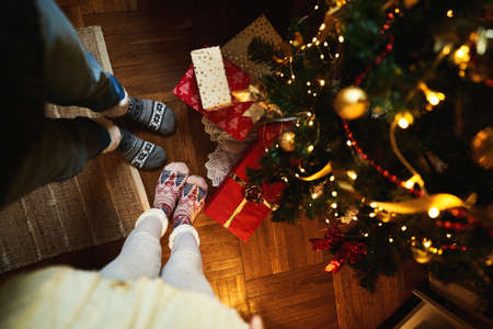 Top view Couple in Christmas socks near decorated xmas tree with gift and present boxes. Winter holiday Xmas and New Year conceptの写真素材
