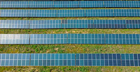Top view solar panels on green field, electric solar farm alternative electricity source.の写真素材