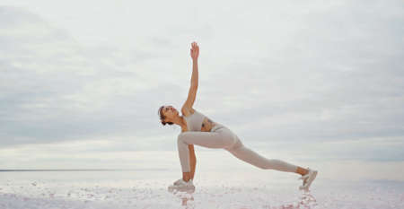 confindent sportive woman doing yoga outdoors with beautiful serenity natural view. Concept of wellness and harmony with natureの写真素材
