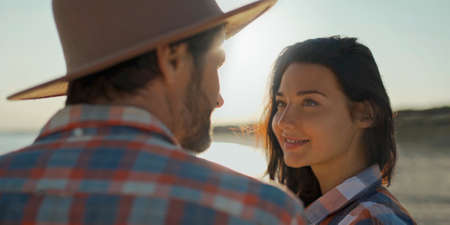 Close-up portrait woman looking at her boyfriend with tender and love at sunset lights.の写真素材