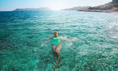 Smiling woman lying on her back floating in the sea water, relaxing on vacation, Travelling tour in Turkeyの写真素材
