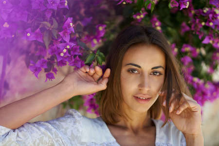 Beauty portrait close up face young attractive woman in spring garden with pink flowersの写真素材