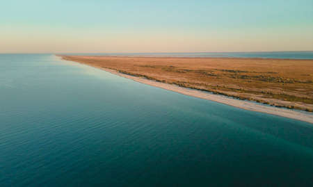 Panoramic landscape of sandy beach and clear blue sea water at sunset. Banner image seascape from air. Dzharylhach island, Ukraineの写真素材