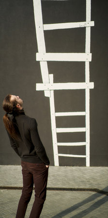 Confident businessman in suit walking out of business center, symbolizing success and career growth in business. Marketing and advertising campaigns concept.の写真素材